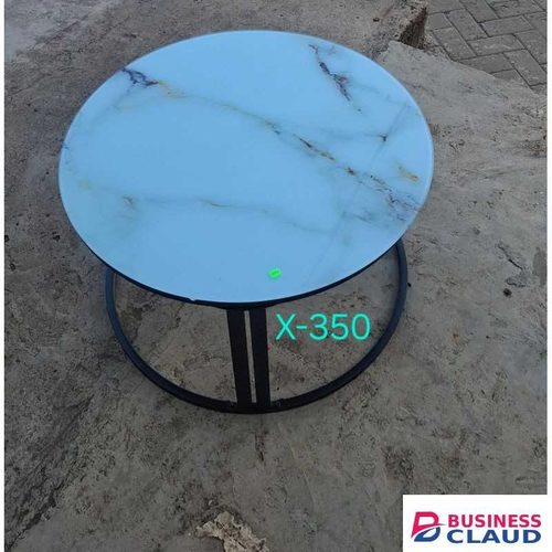 Round glass-top coffee table with a marble-effect surface